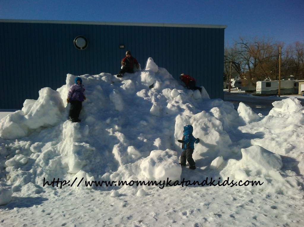 kids climbing a large pile of snow