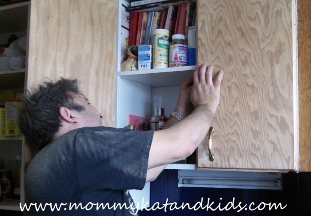 man fixing cupboard doors