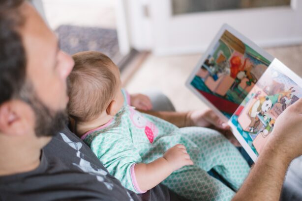 man and baby reading