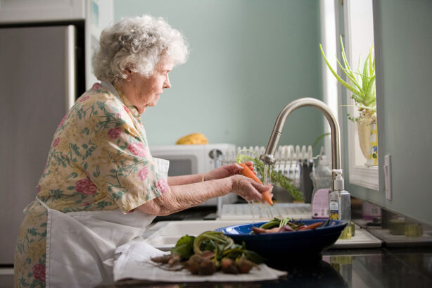 senior-woman-washing-vegetables