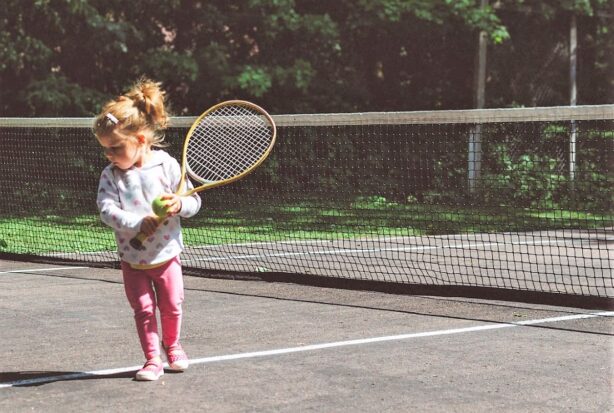 girl playing tennis outside
