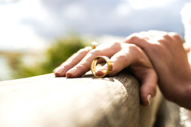 man's hand holding wedding ring