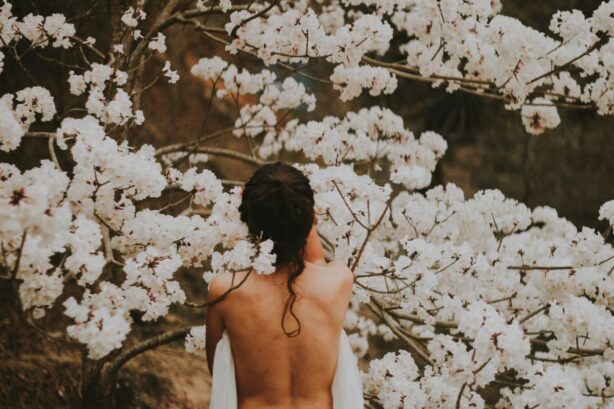 woman standing in white flowered trees