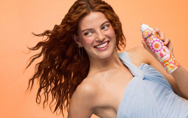 woman holding perk up dry shampoo bottle